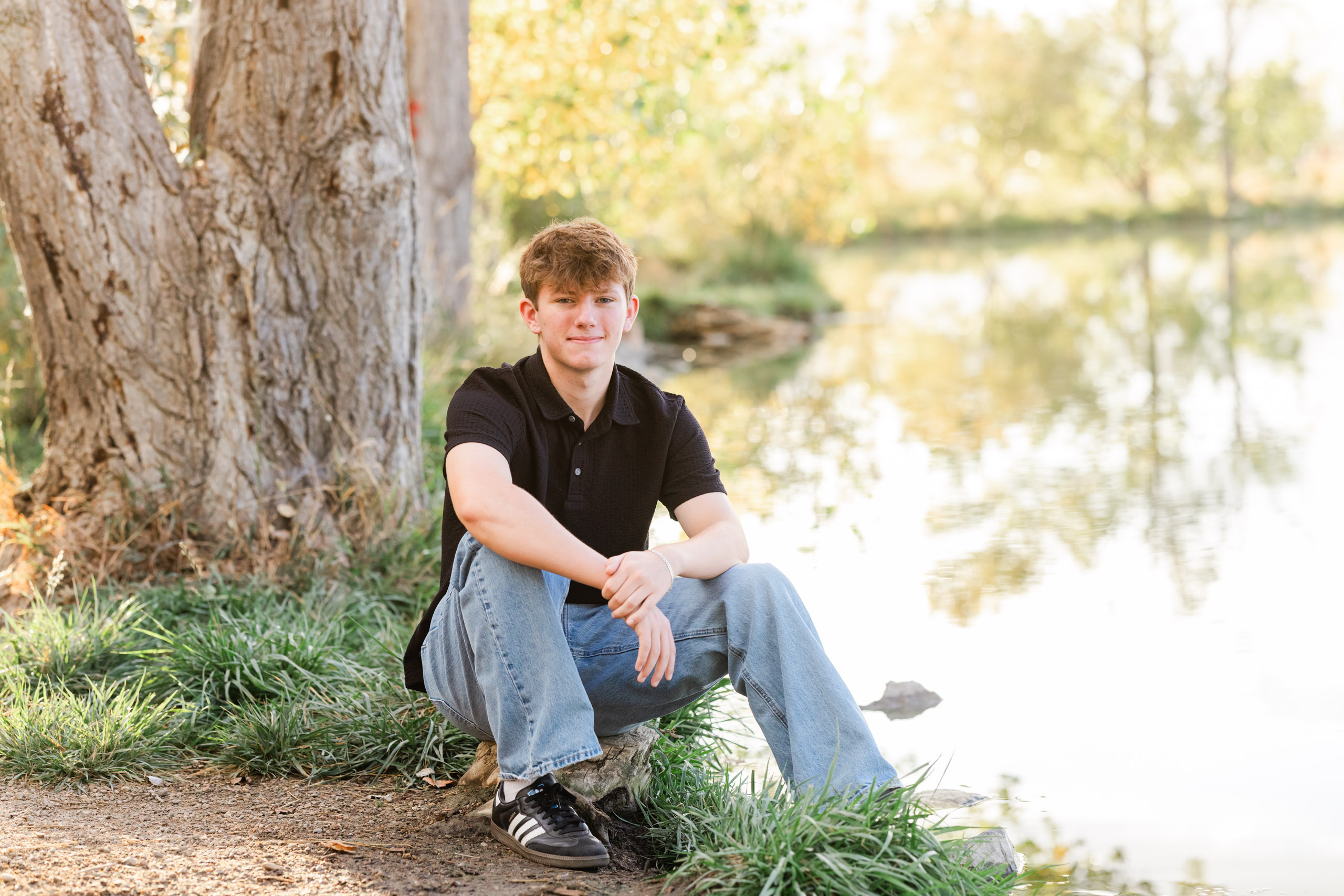 A high school senior guy smiling and posing along the nature trails at Coot Lake in Boulder, Colorado, with peaceful lake views and mountain foothills in the background. A high school senior guy smiling and posing along the nature trails at Coot Lake in Boulder, Colorado, with peaceful lake views and mountain foothills in the background.